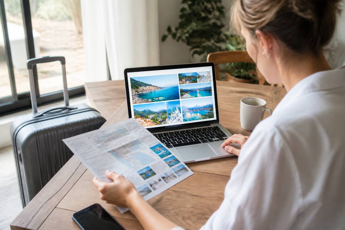 Reiziger die reizen en vakanties vergelijkt op laptop en met notities